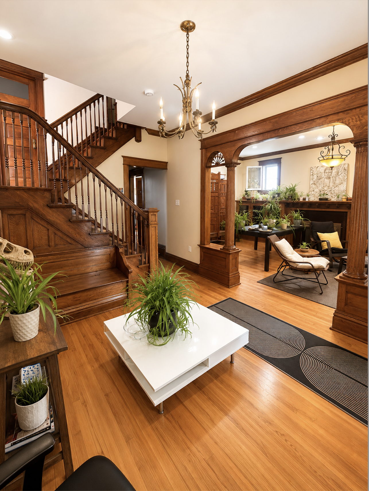 Denver Coliving — historic living room with staircase and chandelier
