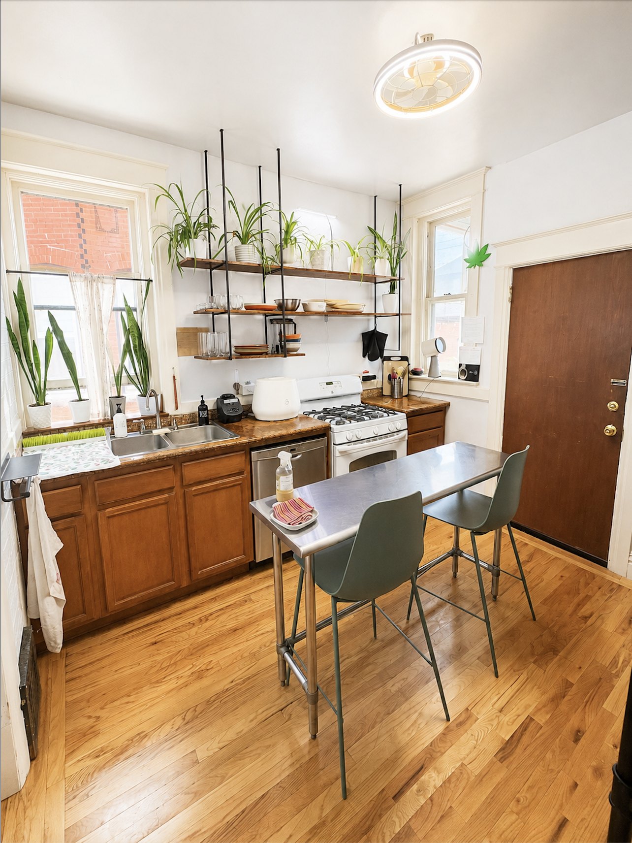 Kitchen with gas stove, plants, and bar seating