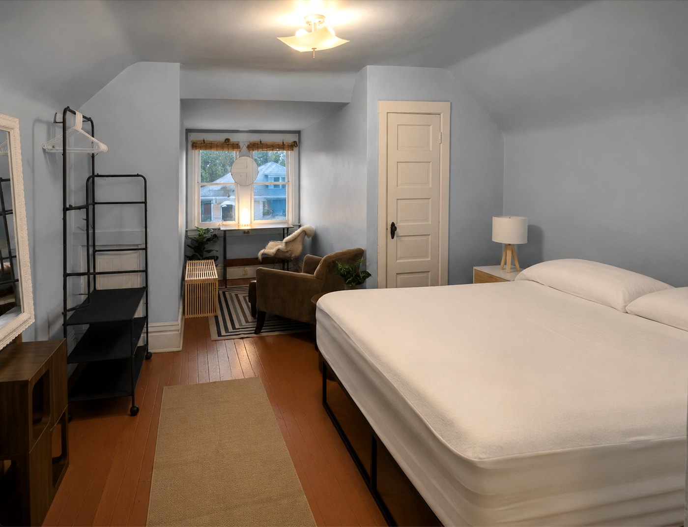 Room 1 — blue-walled third floor room with a king bed, seating area, desk and west-facing window